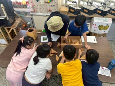 由知本自然教育中心講師帶領學童觀察國產材教具，介紹不同樹種的木紋特色。